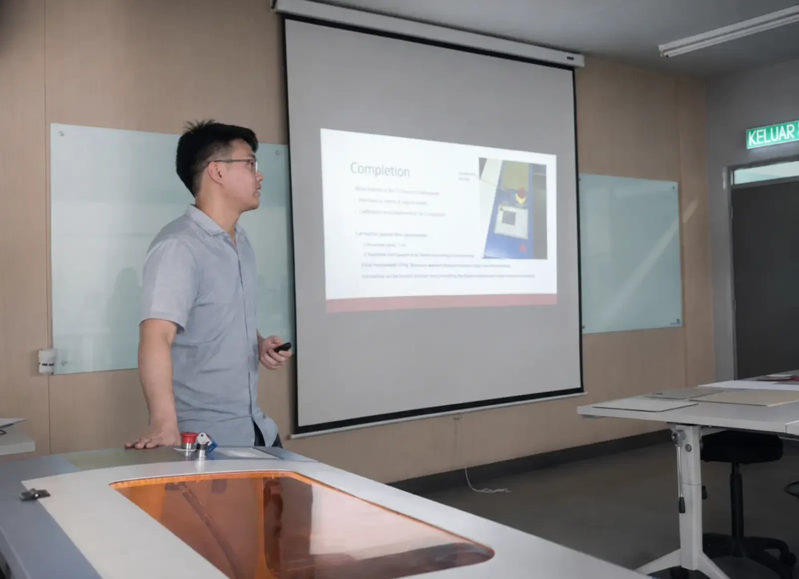 Instructor presenting laser machine operation during operator training